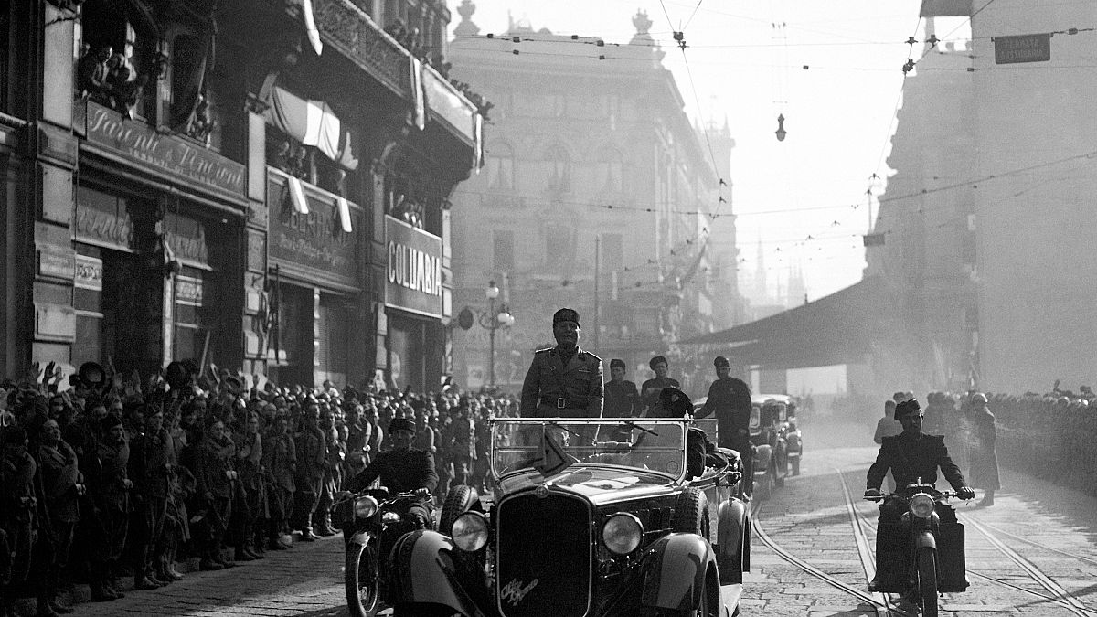 FILE: Italian dictator Benito Mussolini, standing in his car, drives through the streets of Milan, on Oct. 30, 1936.