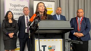 Flanked by lawmakers, New Zealand Prime Minister Jacinda Ardern delivers a speech on Aug. 12, 2021, in Wellington, New Zealand.