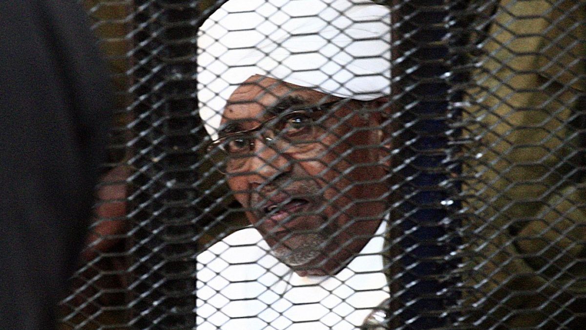 In this file photo taken in August 2019, Sudan's deposed military ruler Omar al-Bashir looks on from a defendant's cage during the opening of his corruption trial in Khartoum.
