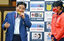 4 agosto 2021: il sindaco di Nagoya Takashi Kawamura, a sinistra, morde la medaglia d'oro olimpica di Miu Goto, a destra, dalla squadra di softball giapponese,