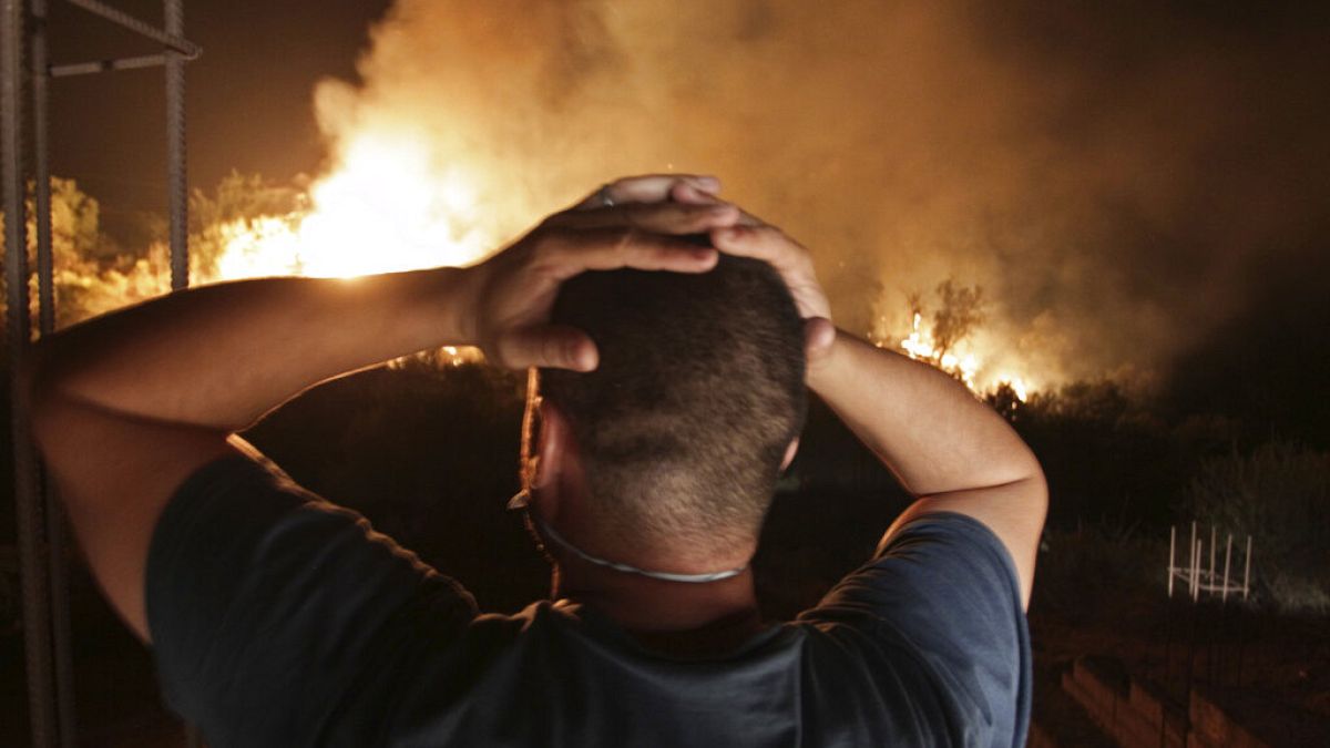 ينظر رجل إلى حريق غابة بالقرب من قرية أربا ناث إراثن في تيزي وزو بمنطقة القبائل الجبلية- 11 آب / أعسطش 2021