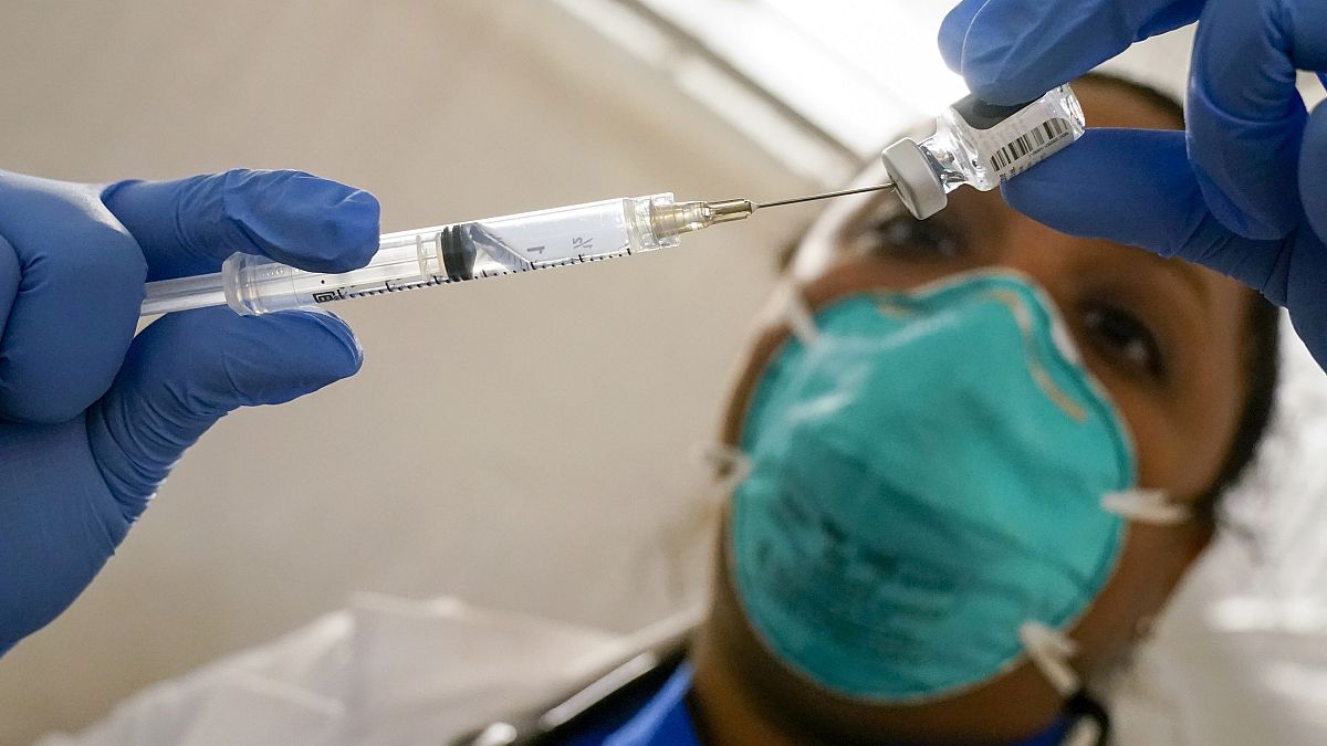 A health worker extracts the Pfizer COVID-19 Vaccine out of a vial at a vaccination site in the East Harlem, New York, Jan. 15, 2021.