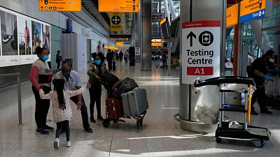 Travellers walk towards the Covid-19 testing centre at Heathrow Airport in London. Travellers walk towards the Covid-19 testing centre at Heathrow Airport in London.