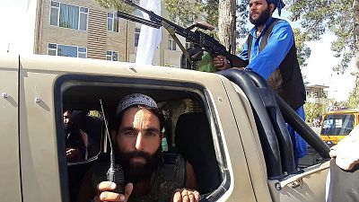 Taliban fighters in a vehicle along the roadside in Herat.