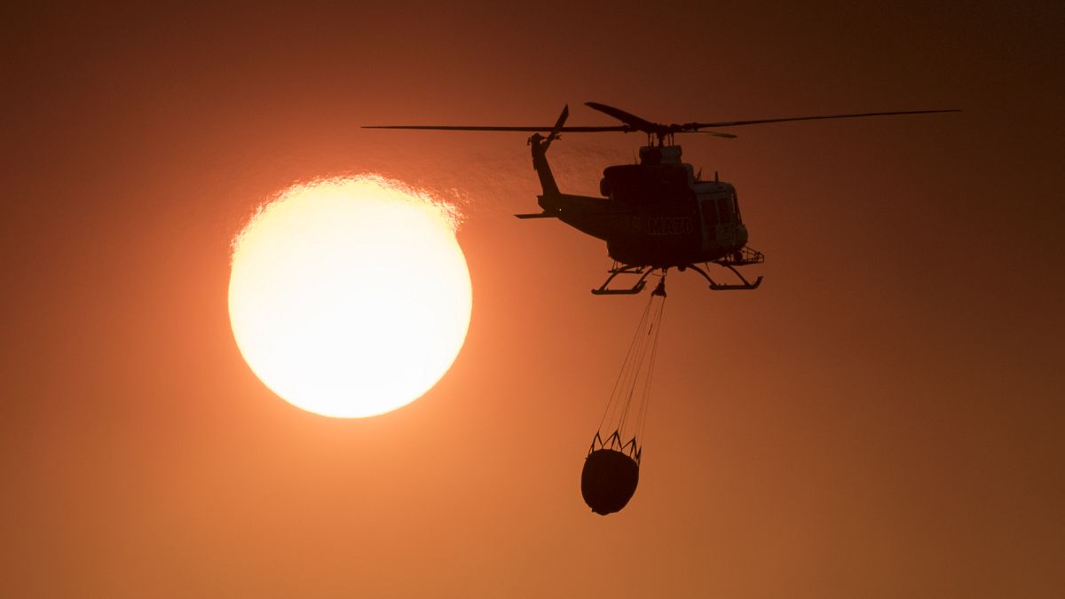 Пожарный вертолёт в задымлённом небе Андалусии
