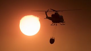 Пожарный вертолёт в задымлённом небе Андалусии