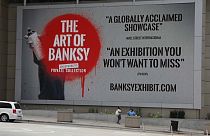 Il cartellone che pubblicizza la mostra di Banksy a Chicago.