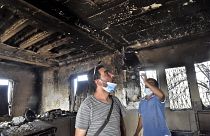 Algerians inspect the damage at their home due to forest fires.