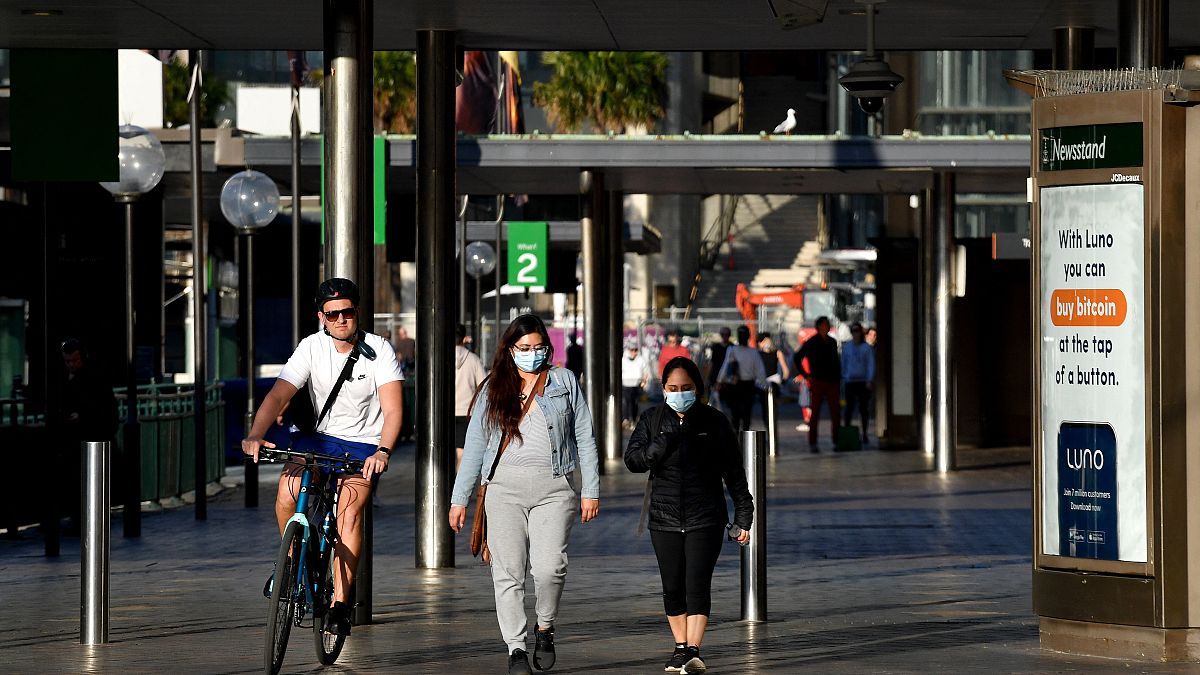 أشخاص يسيرون على  إمتداد ميناء سيدني حيث أعلنت أكبر مدينة في أستراليا قيوداً أكثر صرامة لمواجهة الجائحة. السبت 14 آب / أغسطس 2021