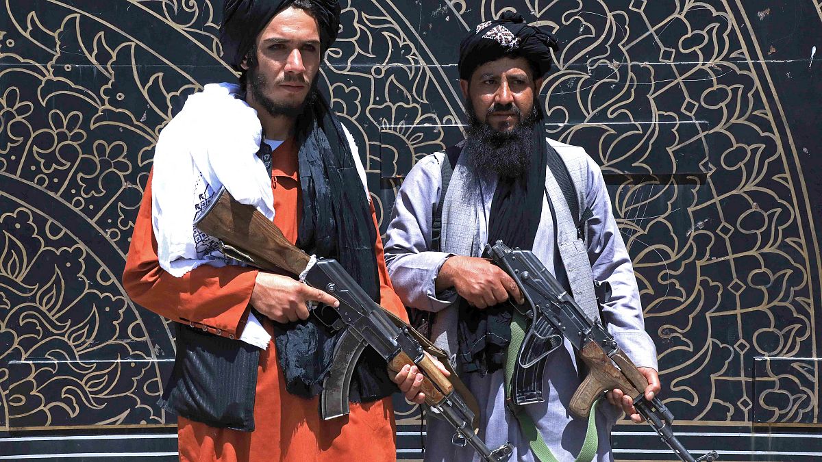 Taliban fighters stand guard in front of the provincial governor's office in Herat on August 14, 2021. 