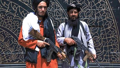 Taliban fighters stand guard in front of the provincial governor's office in Herat on August 14, 2021. 