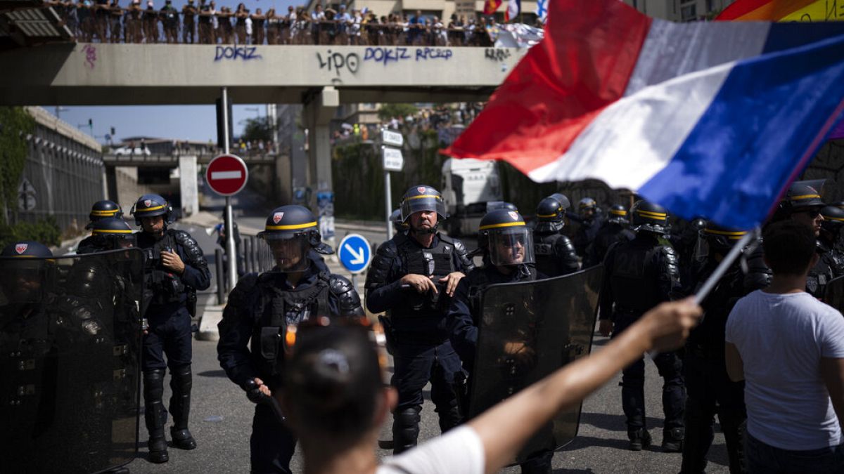 Manifestantes se enfrentan a la policía antidisturbios francesa durante una manifestación en Marsella, sur de Francia, el sábado 14 de agosto de 2021.