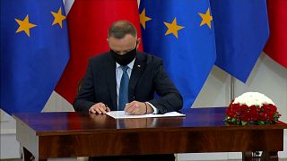 El presidente polaco, Andrzej Duda, firma una ley