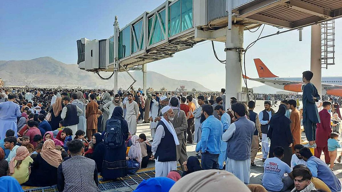 الأفغان يحتشدون في مطار كابل بينما يقف الجنود الأمريكيون في المدرج، أفغانستان، 16 أغسطس 2021.