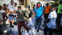 أشخاص يحملون جثة انتشلت من تحت أنقاض زلزال دمر منزله في ليس كاي، هايتي، الأحد 15 أغسطس 2021