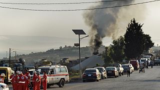 متطوعو الصليب الأحمر اللبناني يتجمعون في شارع بجوار مكان انفجار صهريج وقود في قرية تليل، شمال لبنان.