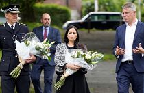 Britain's Home Secretary Priti Patel arrives with Chief Constable Shaun Sawyer and Labour MP Luke Pollard to lay a floral tribute to the victims of the August 12 shootings