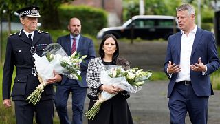 Britain's Home Secretary Priti Patel arrives with Chief Constable Shaun Sawyer and Labour MP Luke Pollard to lay a floral tribute to the victims of the August 12 shootings