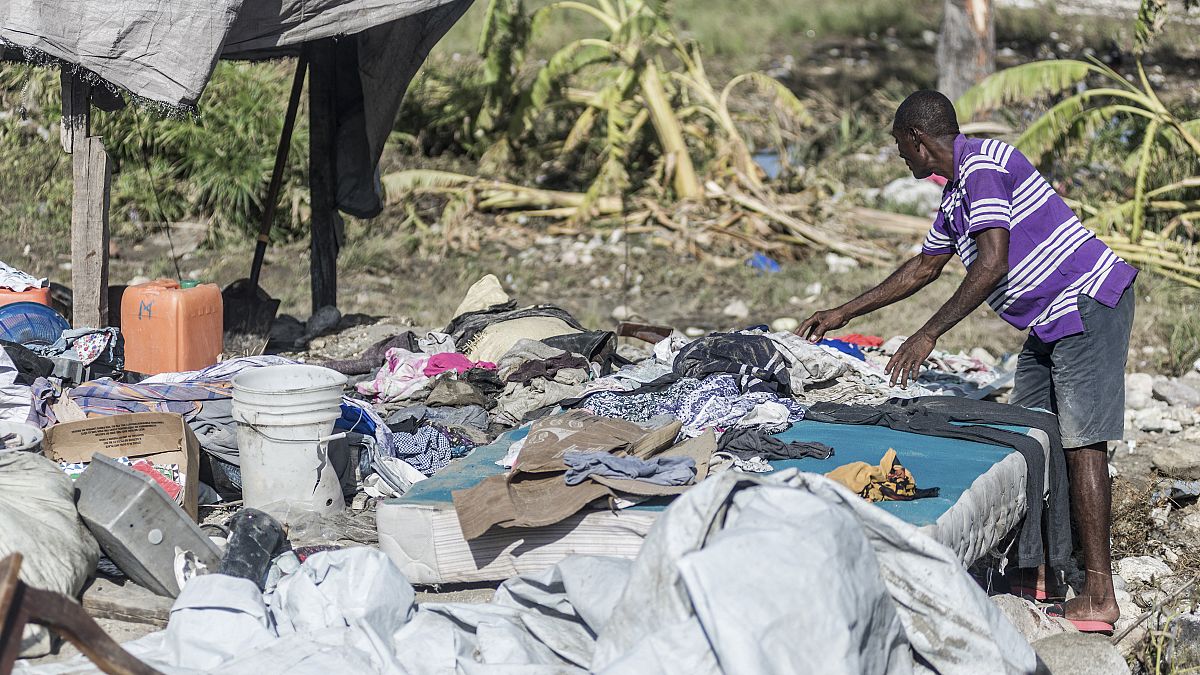 Un homme à la recherche de ses biens dans les débris de sa maison effondrée après le séisme de samedi - Port-à-Piment (Haïti), le 16/08/2021