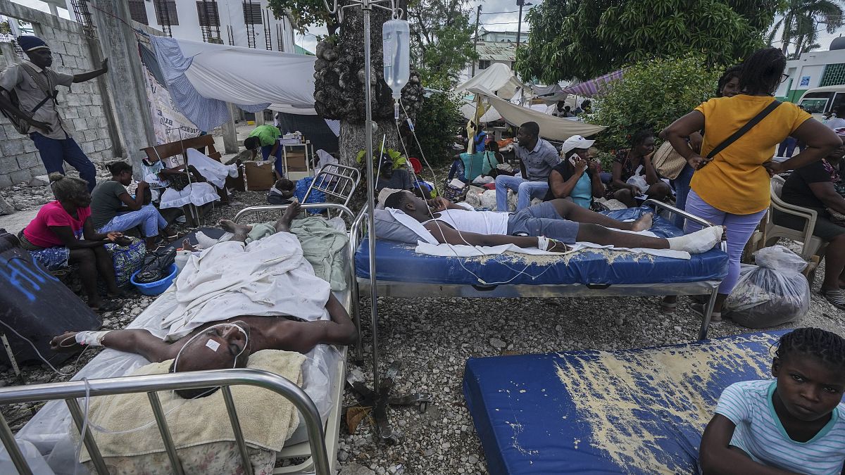 Injured people lie in beds outside the Immaculée Conception hospital in Les Cayes, Haiti, Monday, Aug. 16, 2021