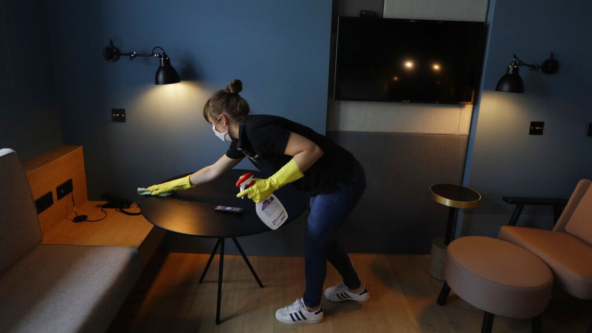 Un limpiadora de hotel prepara una habitación para los clientes