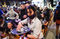 A waitress serves drinks at tables outside a pub in Soho, London as COVID-19 restrictions are eased on April 12, 2021.