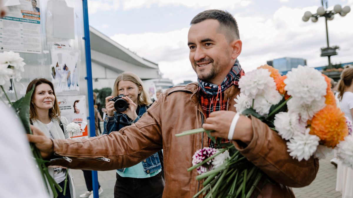 Szcjapan Latipau virágokat oszt egy tüntetésen Minszkben 2020. augusztus 12-én