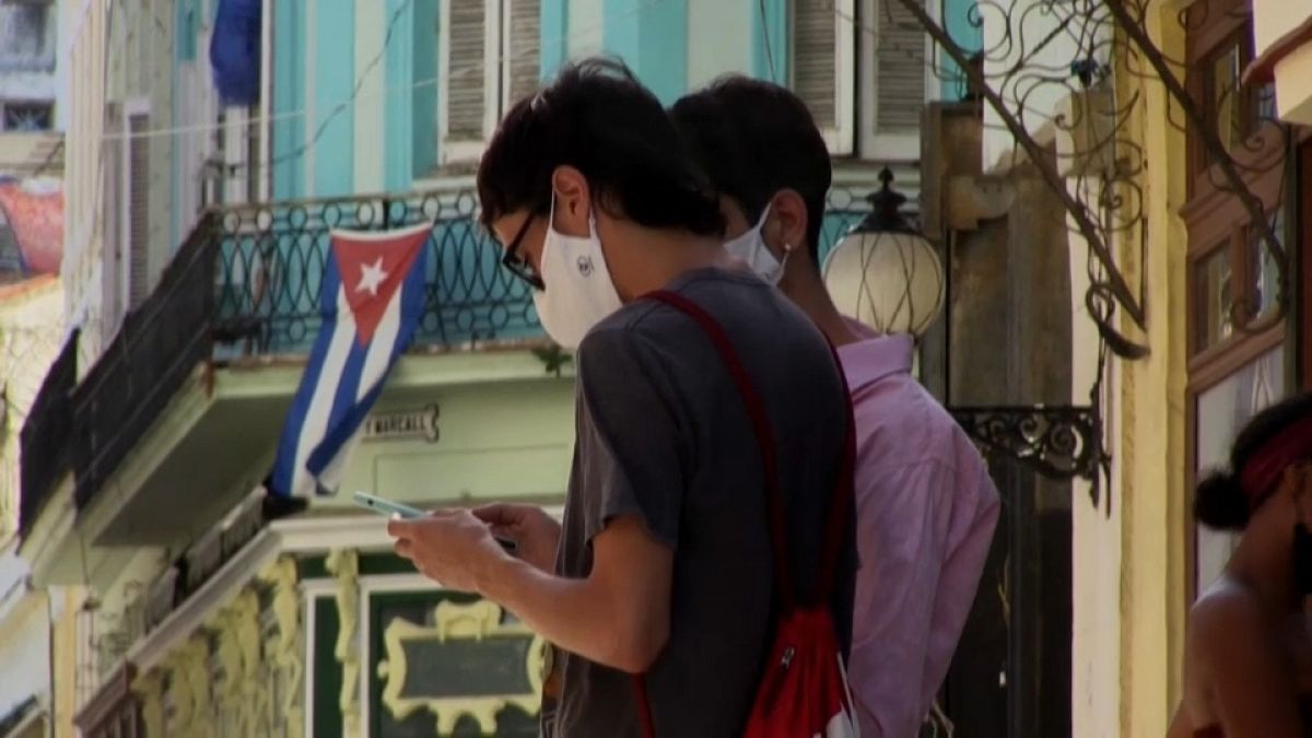 Un joven consulta su teléfono móvil en una calle de La Habana.