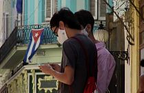 Un joven consulta su teléfono móvil en una calle de La Habana.