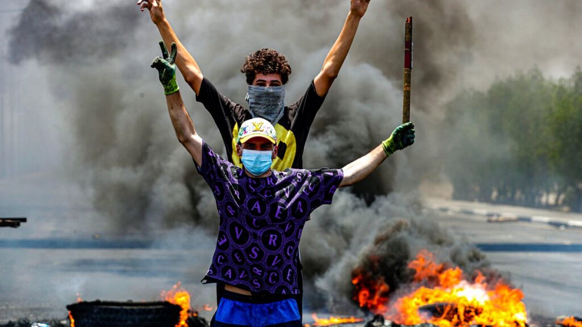 متظاهرون يحرقون الإطارات لإغلاق الطرق خلال مظاهرة تطالب بإعادة الكهرباء في البصرة، جنوب شرق بغداد، العراق، الجمعة 2 يوليو/تموز 2021