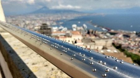 The braille engraved railing at Castel Sant’Elmo with the view of Mount Vesuvius in the background.