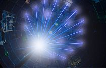 NIF’s high-energy laser beams converge on a target at the center of the target chamber.