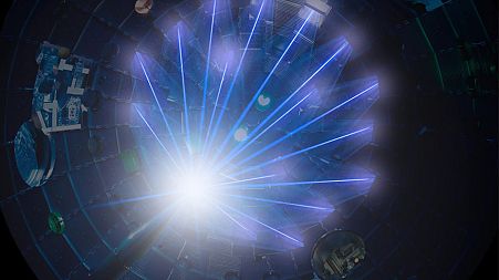 NIF’s high-energy laser beams converge on a target at the center of the target chamber.