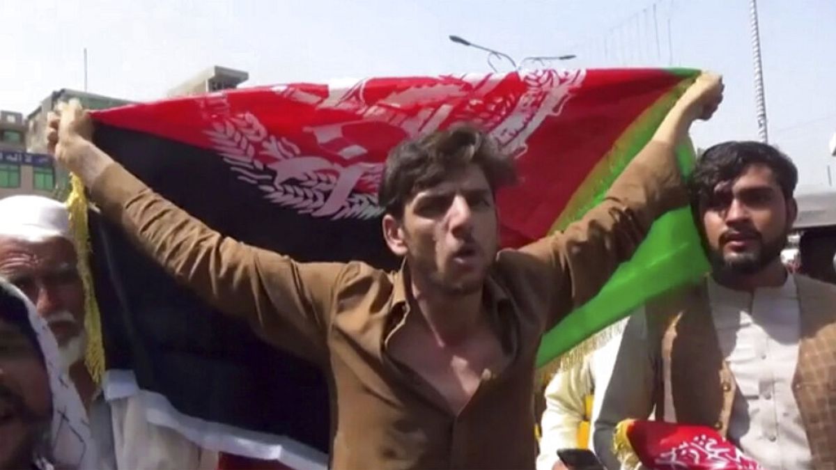 à Jalalabad, en Afghanistan, un manifestant s'oppose au remplacement du drapeau afghan par celui des talibans, le 18 août 2021