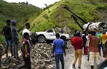 A crane removes a truck from a pile of rocks after landslides triggered by a 7.2-magnitude earthquake that hit four days prior in River Glass, Haiti, Wednesday, Aug. 18, 2021.