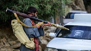 مسلح أفغاني يدعم قوات الأمن الأفغانية ضد طالبان يحمل سلاحًا وهو يسير على طول طريق في بازارك، ولاية بنجشير، أفغانستان، 18 أغسطس 2021