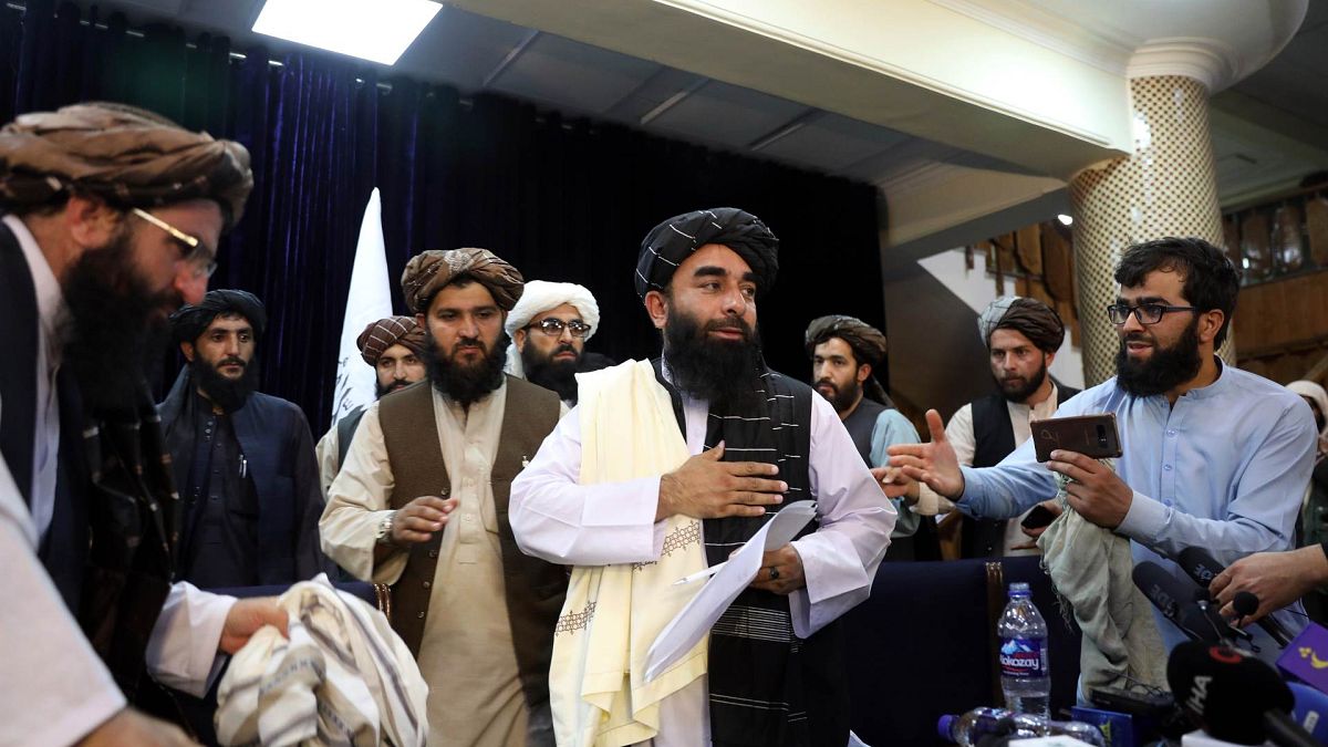 المتحدث باسم طالبان، ذبيح الله مجاهد، وسط الصورة، بعد أول مؤتمر صحفي له في كابول، أفغانستان، 17 أغسطس 2021 
