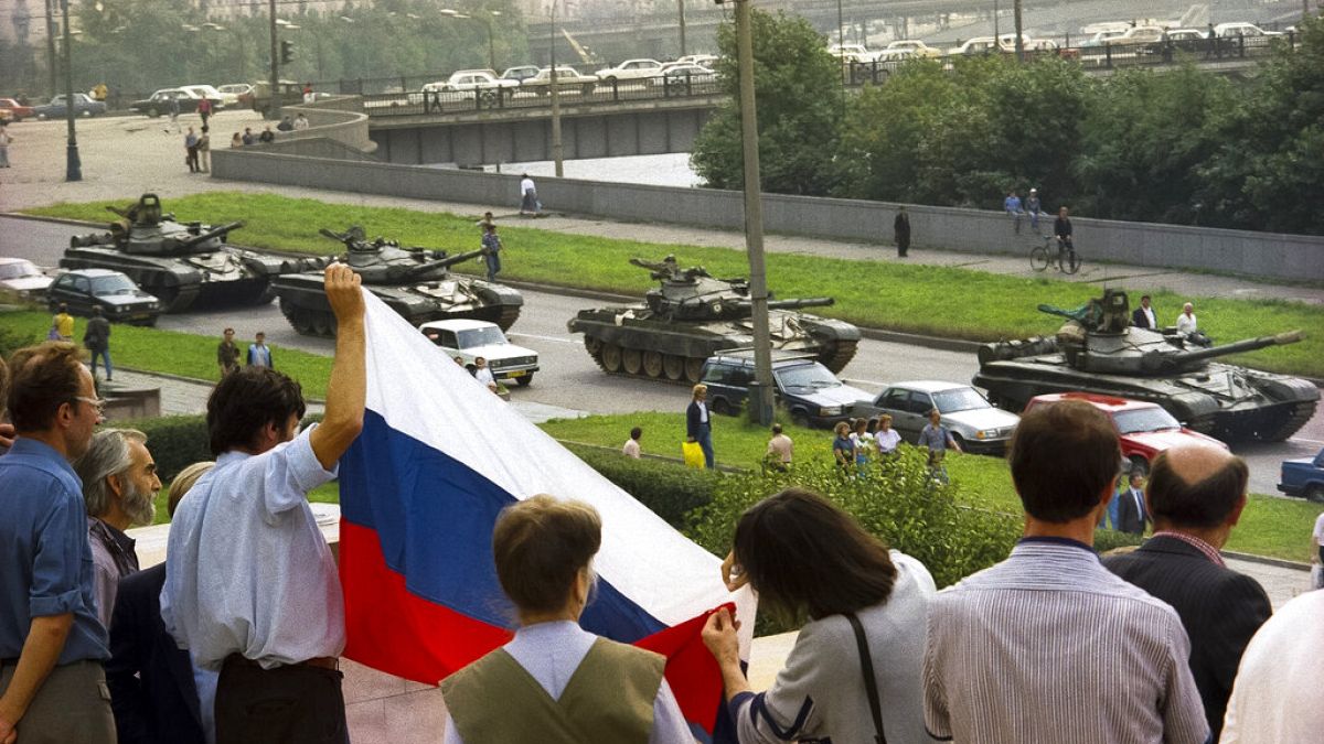 Protesters gather at the Russian Government building holding a Russian national flag to oppose the oncoming line of tanks around the building in Moscow, August 19, 1991.