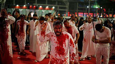 Shiite faithful self-flagellate to show their grief during a Muharram procession marking Ashoura, outside the holy shrine of Imam Hussein in Karbala.