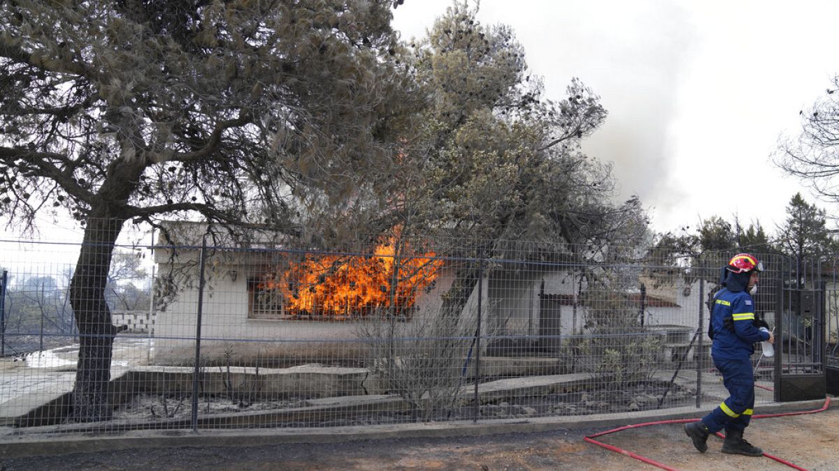 A firefighter extinguish the fire to a house during a wildfire in Thea area some 60 kilometers 