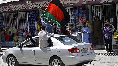 Afghans wave the Afghan flag to defi the Taliban, who have their own flag, on Afghan Independence Day.