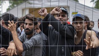 Migrantes detrás de una valla en el campo de refugiados recién construido en el campo de entrenamiento militar de Rudninkai, a unos 38 km al sur de Vilna.