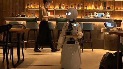 ربات‌های پیشخدمت در کافه‌ای در توکیو از مشتریان پذیرایی می‌کنند