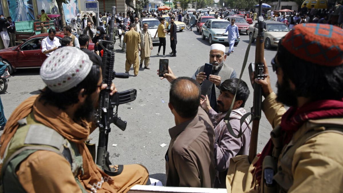 Afgán férfiak tálibokkal szelfiznek Kabulban 
