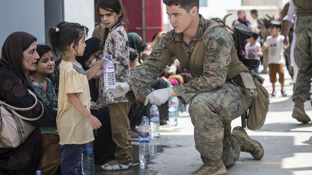 Американский солдат предлагает воду ребенку в аэропорту Кабула