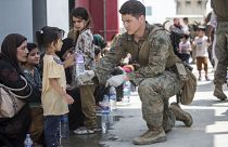 Американский солдат предлагает воду ребенку в аэропорту Кабула