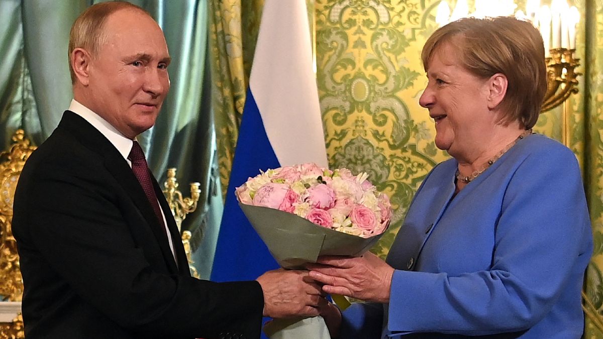 الرئيس الروسي فلاديمير بوتين  يرحب بالمستشارة الألمانية أنجيلا ميركل بباقة من الزهور خلال اجتماعهما في الكرملين في موسكو في 20 أغسطس 2021.