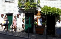 Portekiz'in başkenti Lizbon'da bir kafenin önünden geçen kadınlar