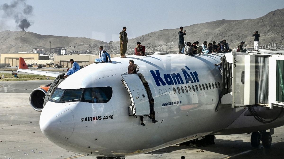 أفغان يتسلقون على متن طائرة من طراز Kam Air (أكبر شركة طيران أفغانية خاصة) أثناء انتظارهم في مطار كابول - 16 أغسطس 2021