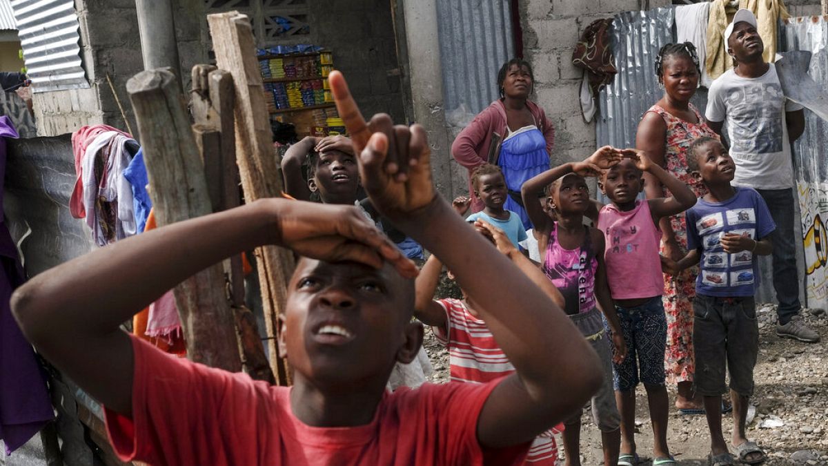 Des sinistrés du séisme guettent l'arrivée d'un hélicoptère transportant de l'aide humanitaire - Près des Cayes (Haïti), le 19/08/2021